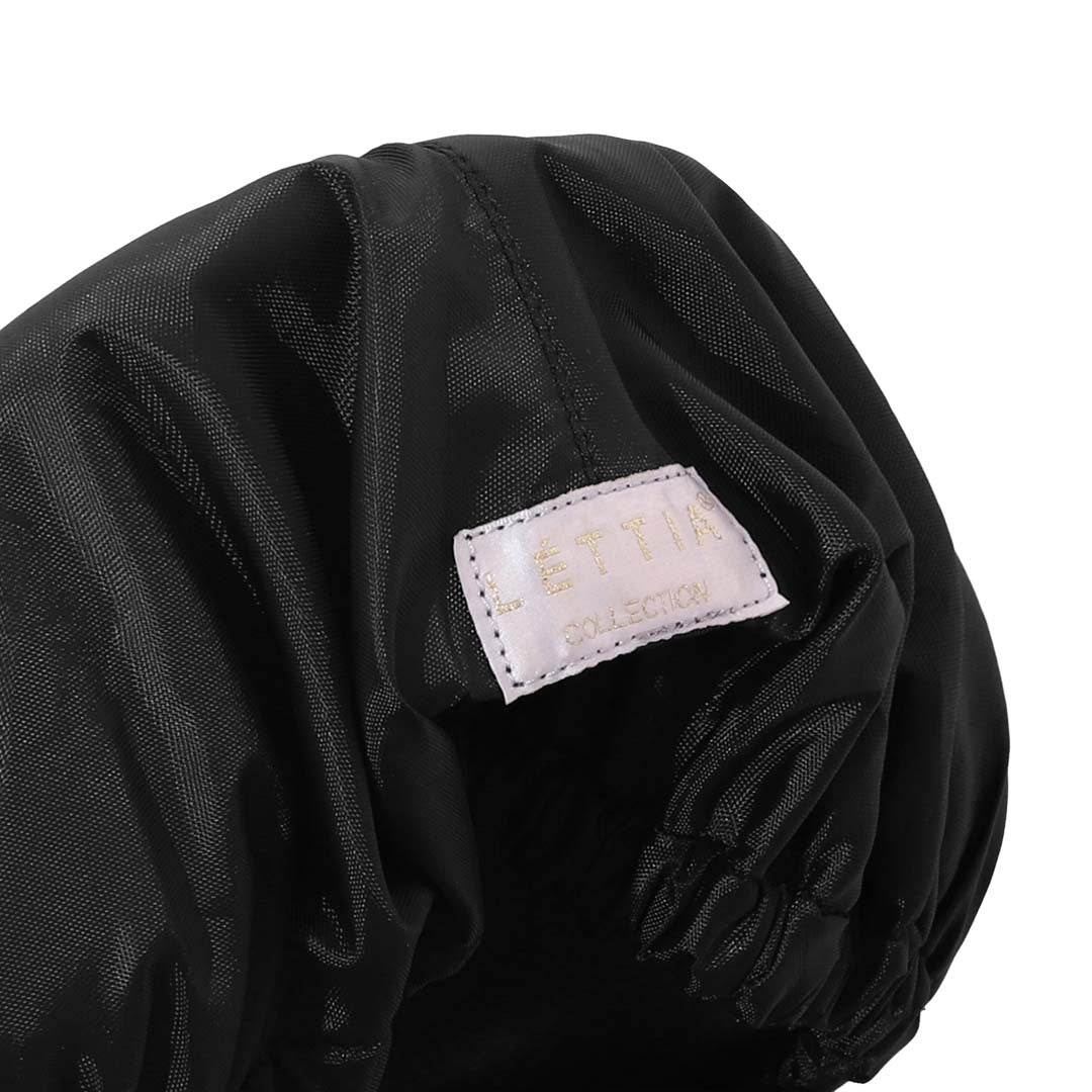Close view of the elastic edge of the black saddle cover and the pale sewn-in label