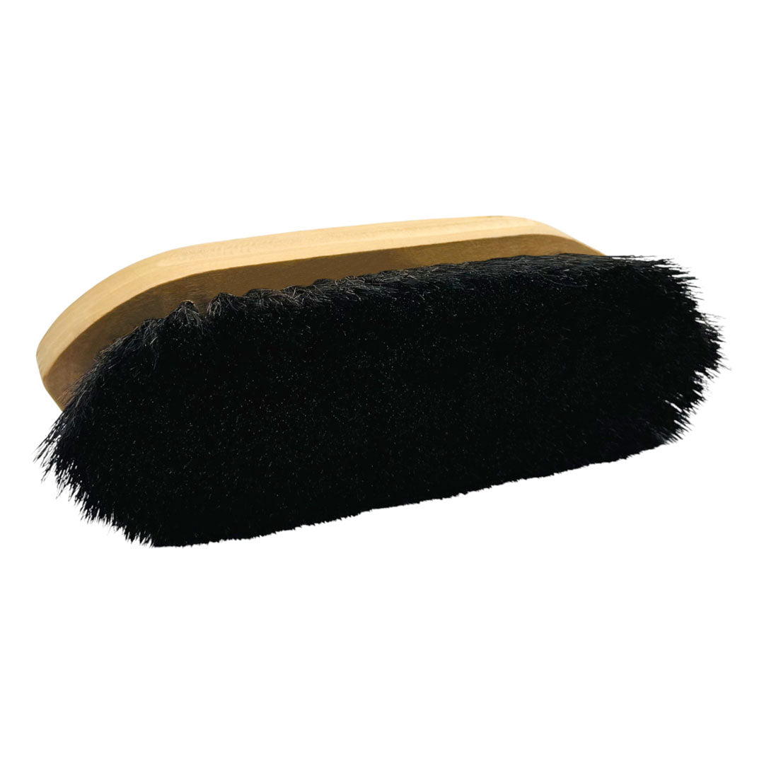Grooming brush turned to show the dense black bristles below the light wood back, on white