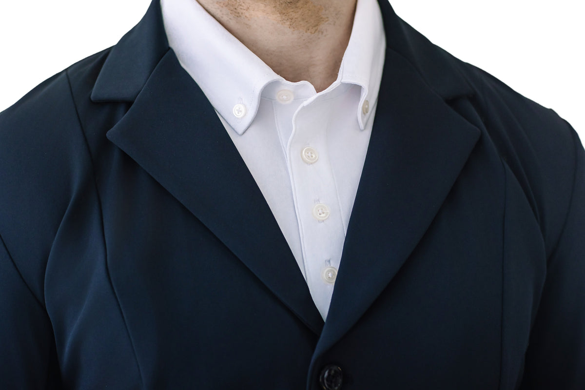 Close-up of the navy show coat lapels and front button over a white collared shirt