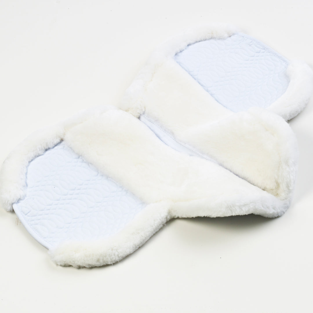 Underside of a white contoured saddle pad laid open, showing white fleece and quilted panels