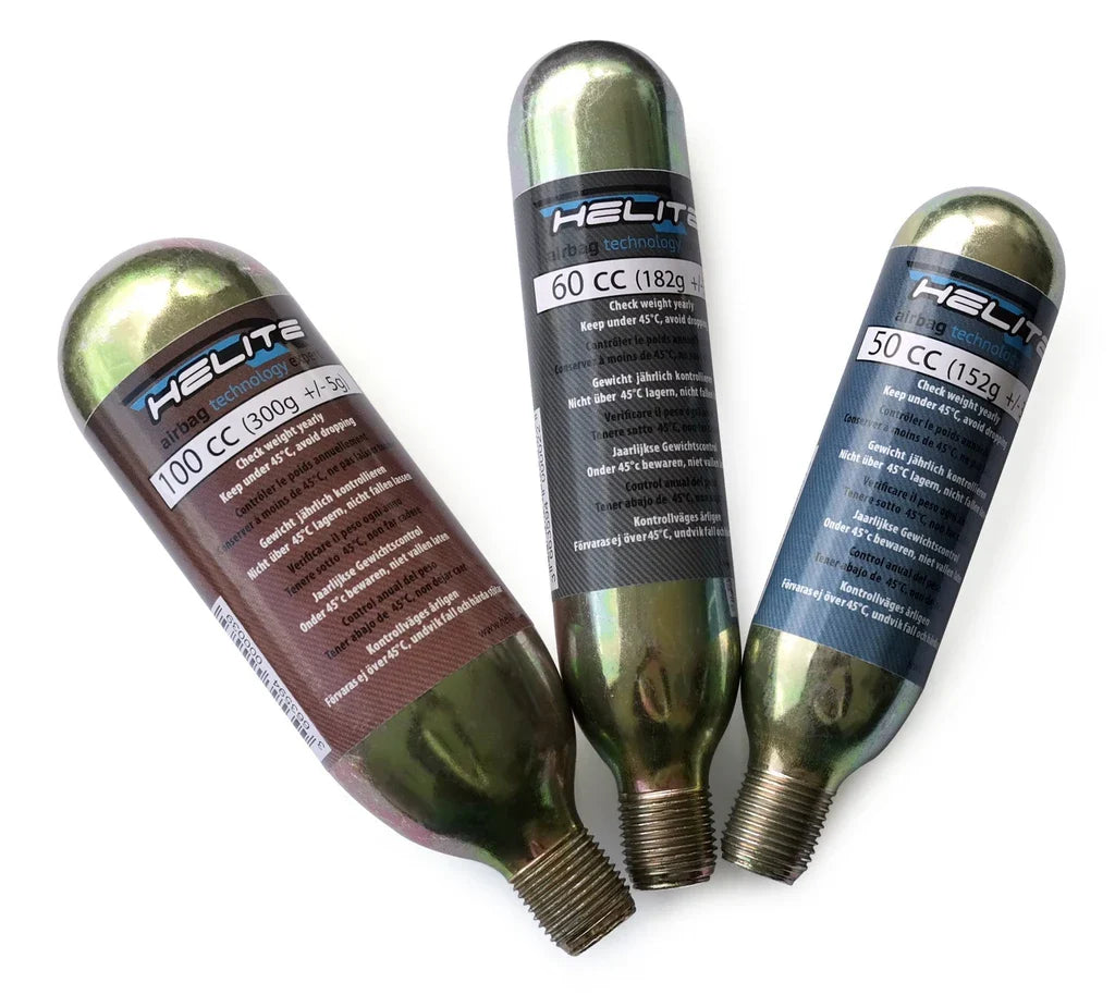 Three Helite CO2 cartridges in different sizes, labeled 100 cc, 60 cc and 50 cc, lying on white