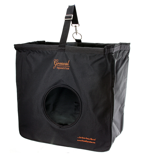 Black hay bag on white with a hanging strap and clip, a round front opening and orange lettering