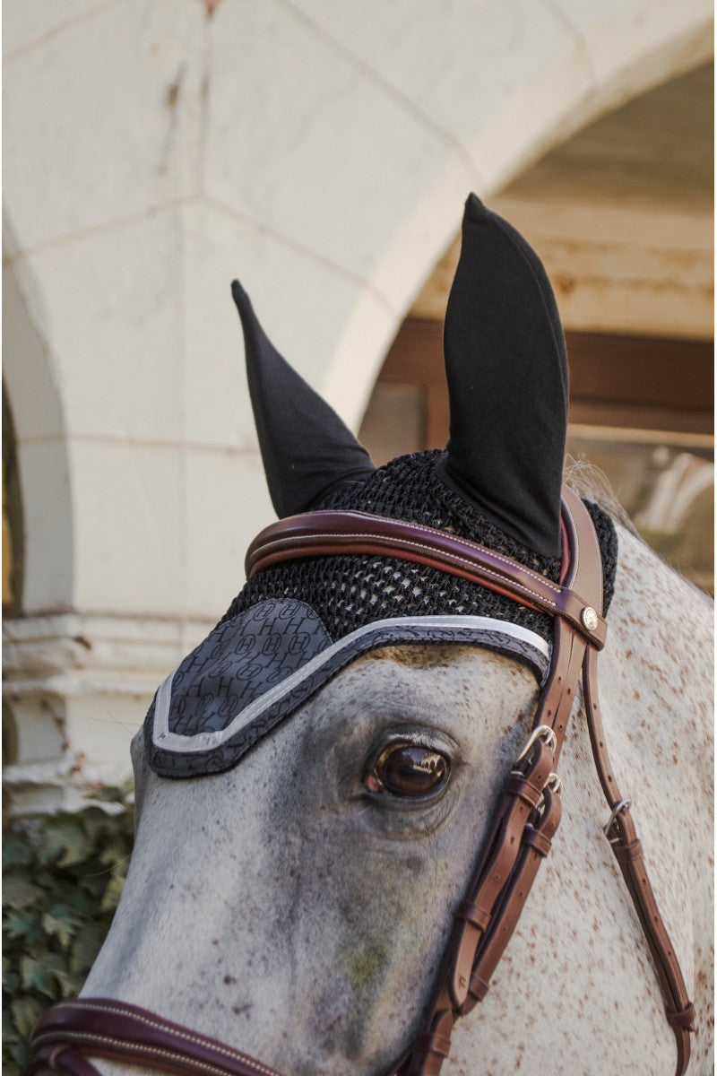 Charcoal fly bonnet with silver trim on a gray horse, side view of the head and bridle