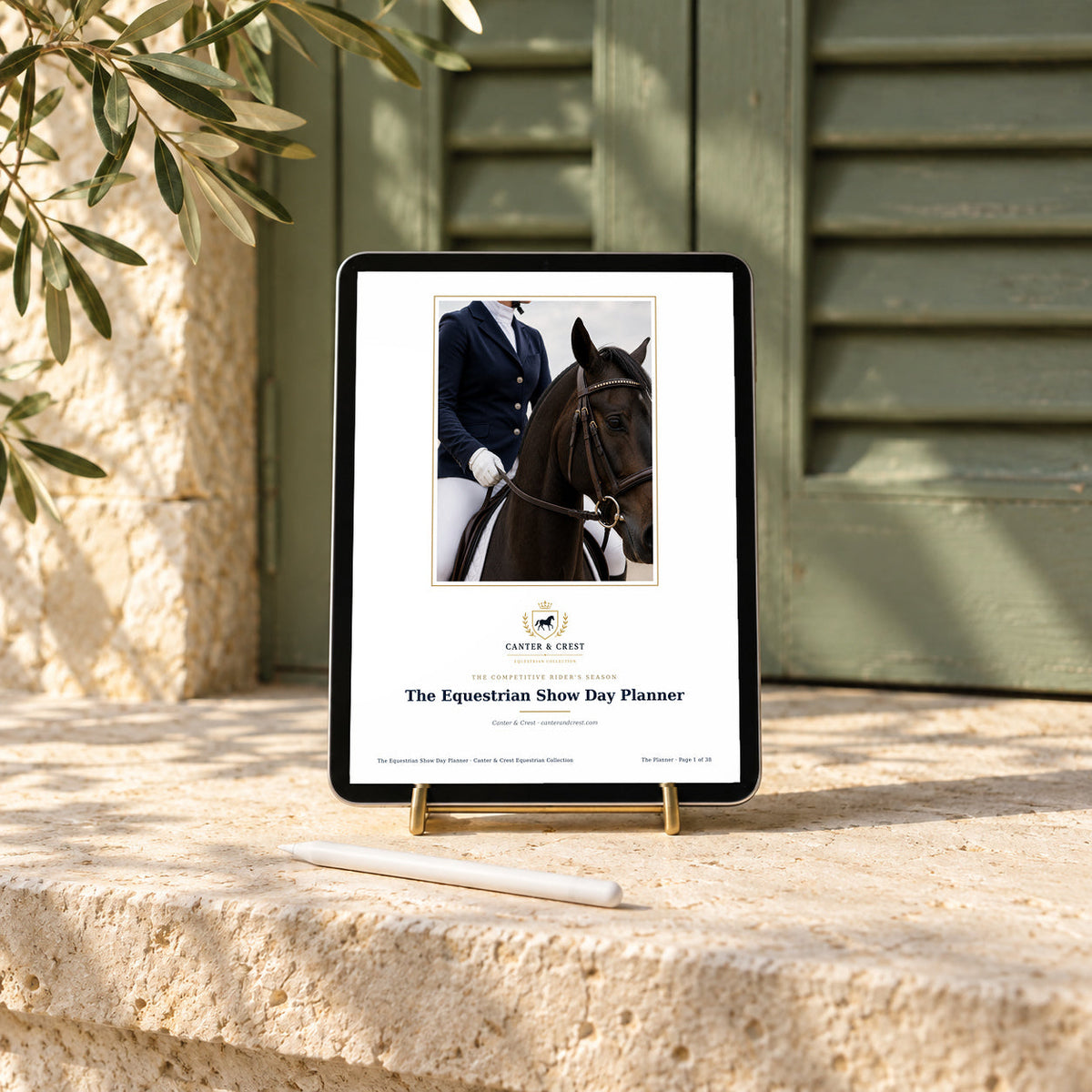 Tablet on a brass stand displaying the Canter and Crest Equestrian Show Day Planner, on a limestone ledge with a sage green shutter and a stylus