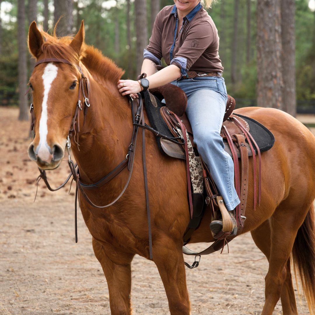 Rider on a chestnut horse with a blaze in a western saddle, the horse wearing a neck strap