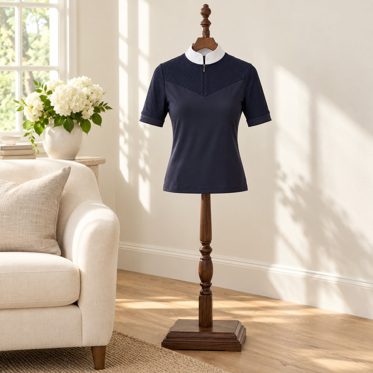 Navy short sleeve show shirt with a white collar on a wooden valet stand in a bright sitting room