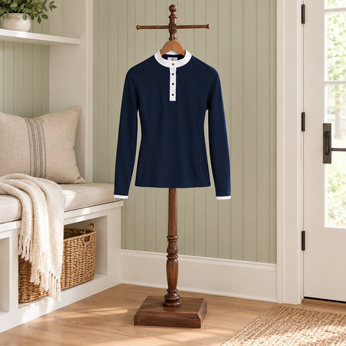 Navy long sleeve riding polo with a white stand collar and placket, on a wooden valet stand in a mudroom