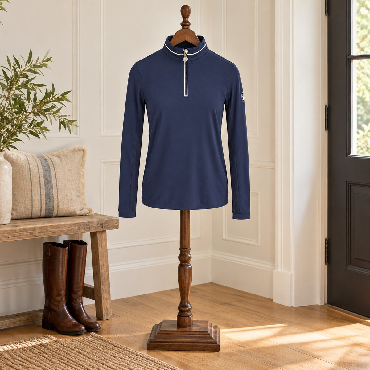 Navy long sleeve quarter-zip sun shirt with white collar piping, on a wooden valet stand in an entry hall