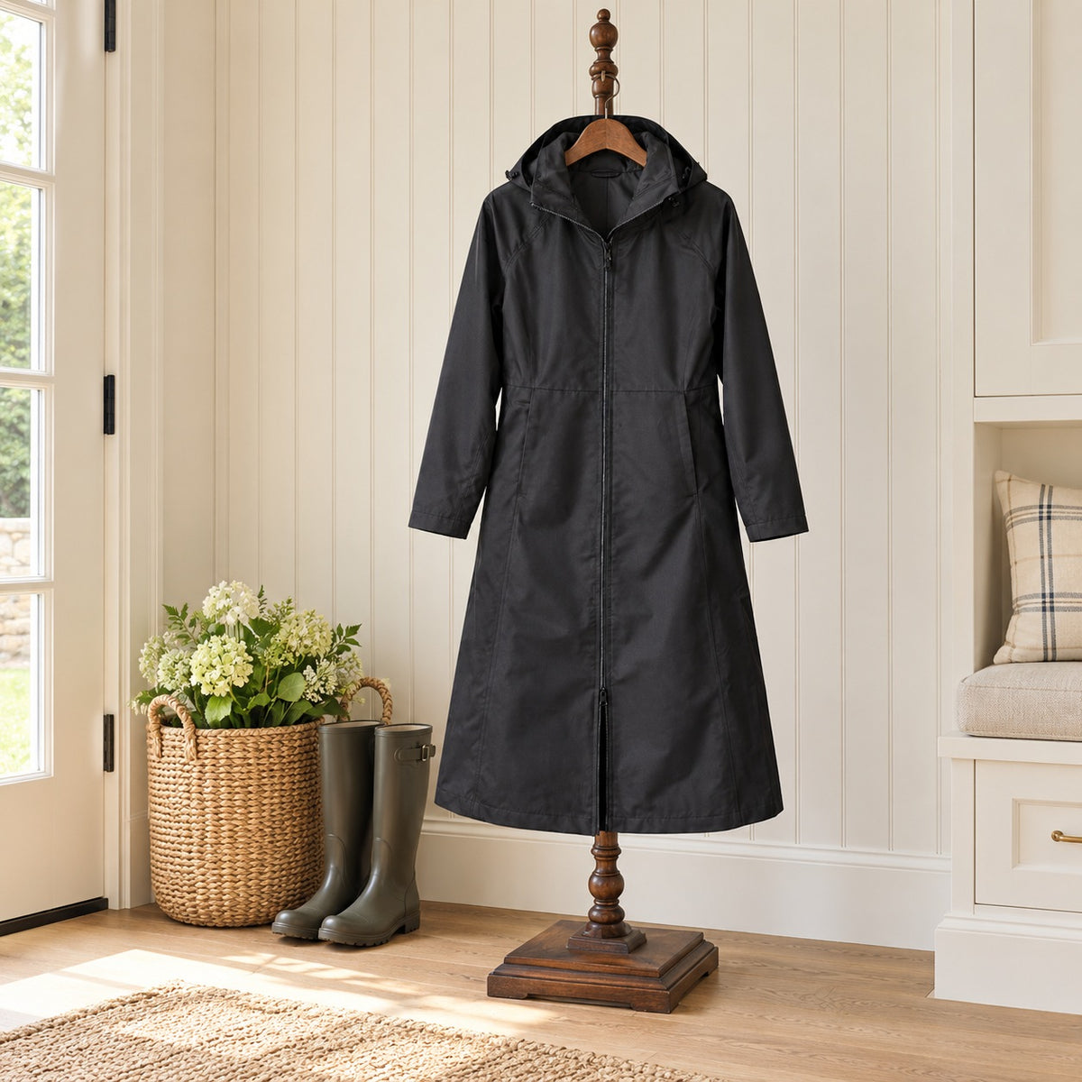 Ovation Rider Raincoat in black on a wooden valet stand in a mudroom