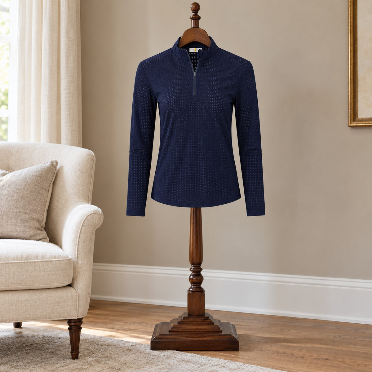 Navy quarter zip with a stand collar and long sleeves, on a wooden valet stand in a sitting room