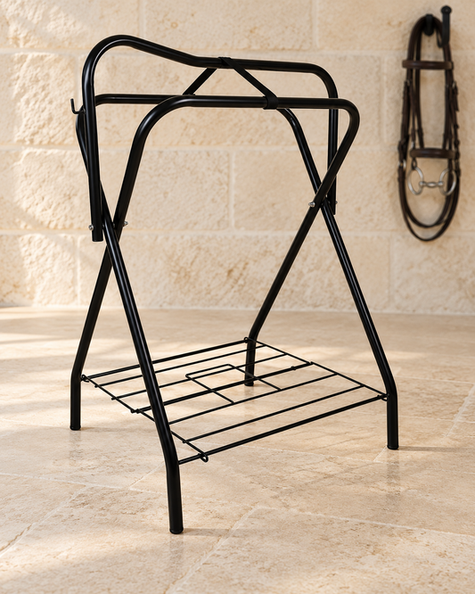 Black HDR folding saddle stand with curved top rails, crossed legs and a wire shelf, standing empty on a limestone tack room floor