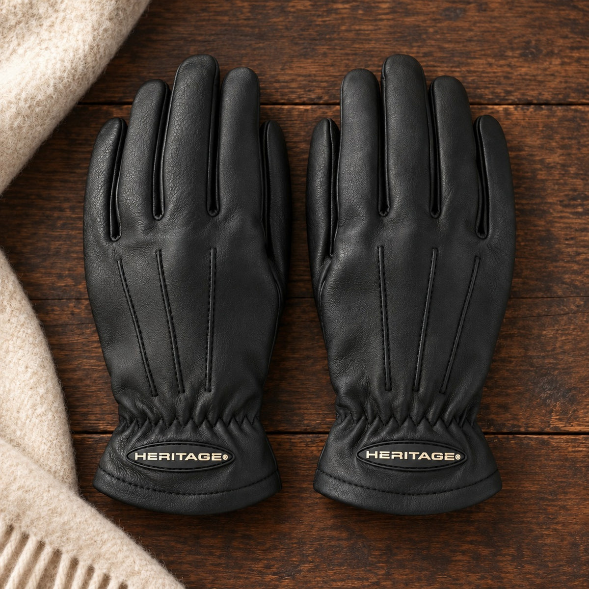 Pair of black leather Heritage Winter Trail gloves on dark walnut