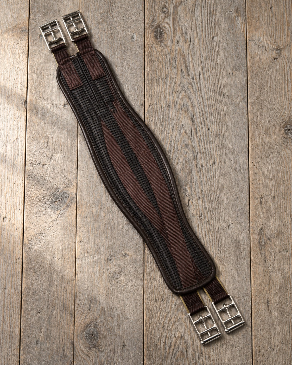 Brown Ovation AirForm all purpose girth lying on grey oak boards