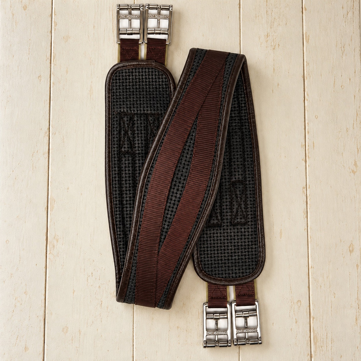 Brown Ovation Airform Click-It girth with black grip lining on cream painted boards