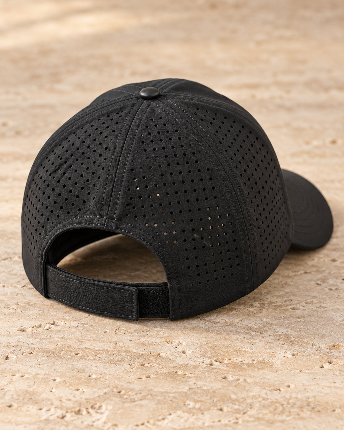 Canter & Crest Signature Crest Perforated Cap in Black, rear three-quarter view showing the perforated panels and the hook and loop closure