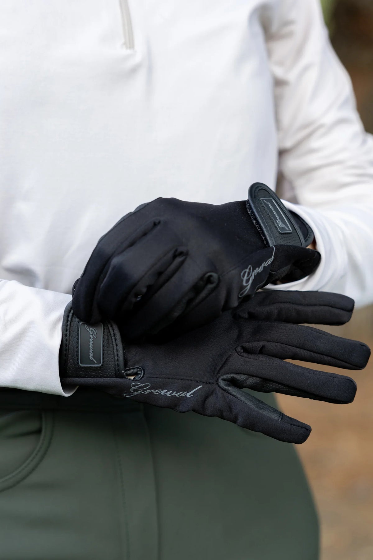 Rider fastening black riding gloves with a hook and loop wrist closure